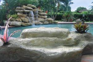 Pool with fountain and tropical landscape design in Miami